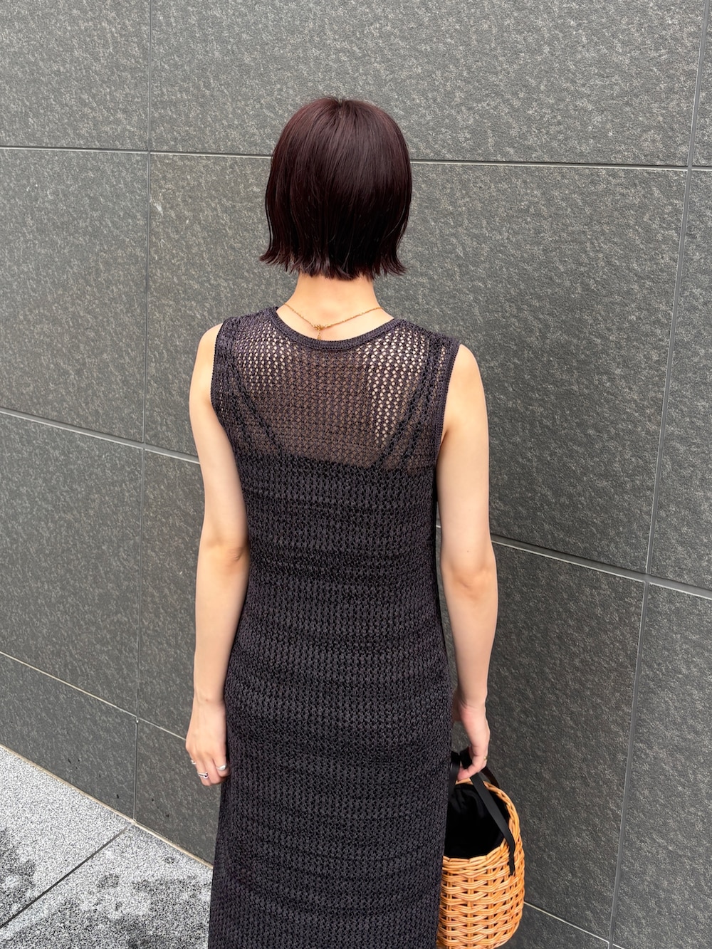 ブラック系のワンピース、ブラウン系のハンドバッグ、ブラック系のサンダルを着用したレディースの夏コーディネートの7枚目の写真