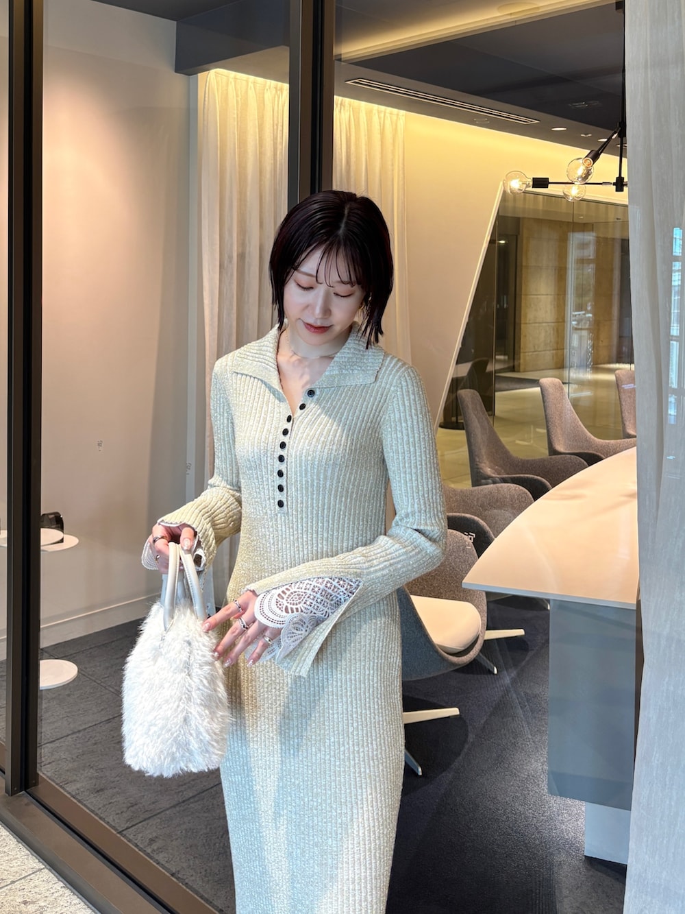 ベージュ系のワンピース、ホワイト系のボストンバッグ、ブラウン系のパンプスを着用したレディースの秋コーディネートの4枚目の写真