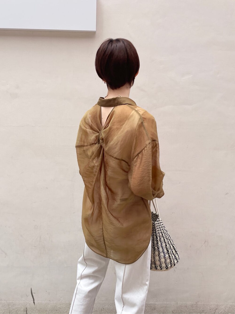 ブラウン系のシャツ/ブラウス、ホワイト系のサンダル、ホワイト系のデニムパンツを着用したレディースの春コーディネートの7枚目の写真
