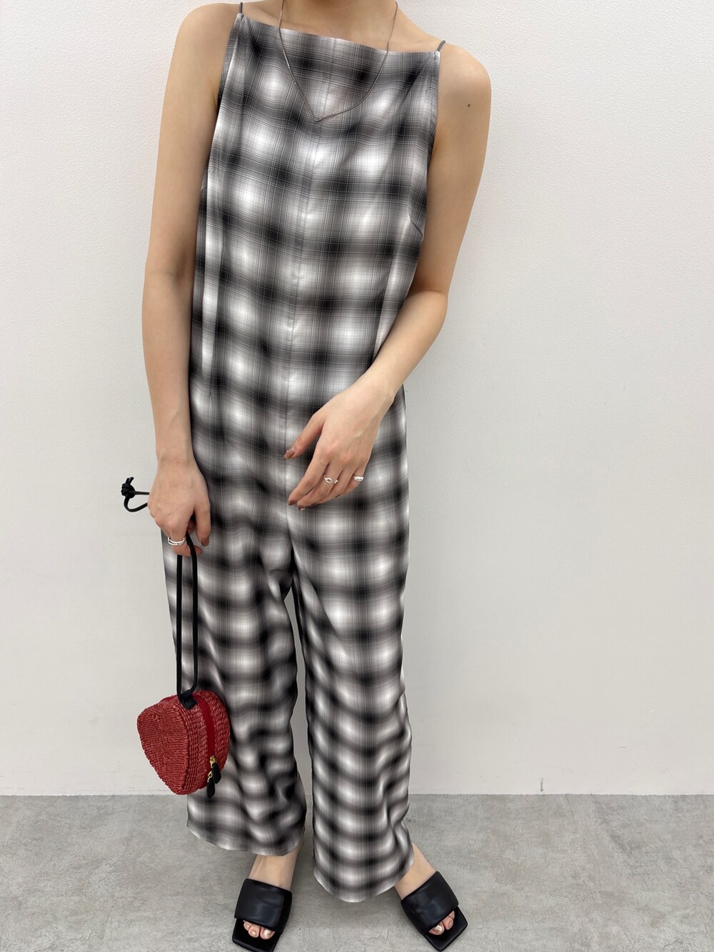 ブラック系のつなぎ/オールインワン、レッド系のショルダーバッグ、ブラック系のサンダルを着用したレディースの春コーディネートの5枚目の写真