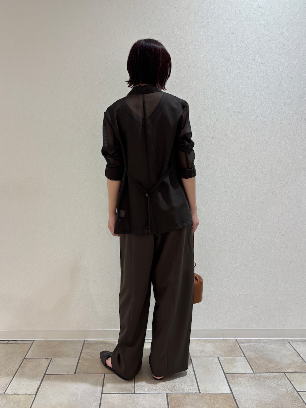 ブラウン系のその他パンツ、グレー系のニット/セーター、イエロー系のハンドバッグを着用したレディースの夏コーディネートの6枚目の写真