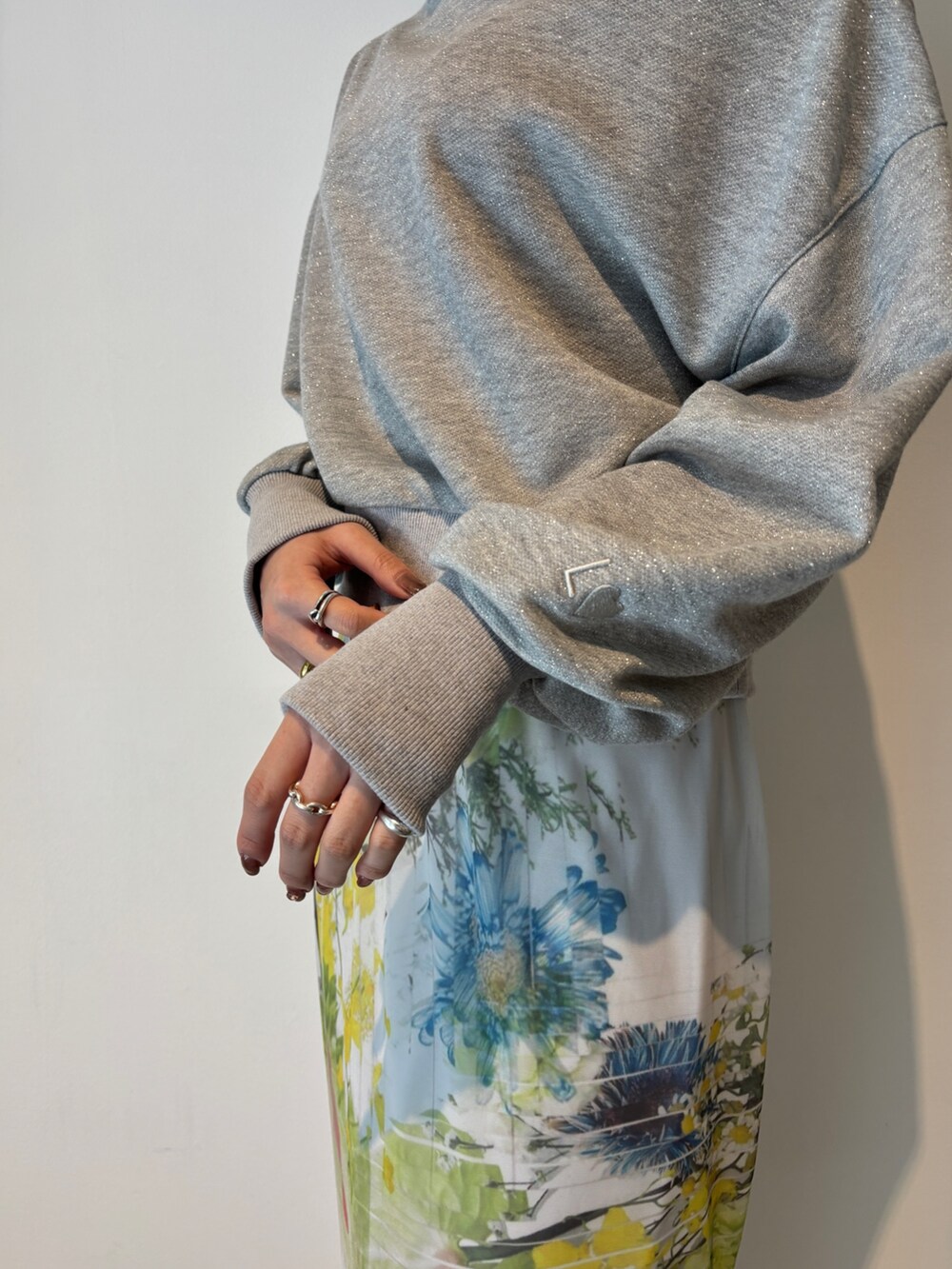 グレー系のスカート、グレー系のスウェット、ホワイト系のサンダルを着用したレディースの冬コーディネートの7枚目の写真