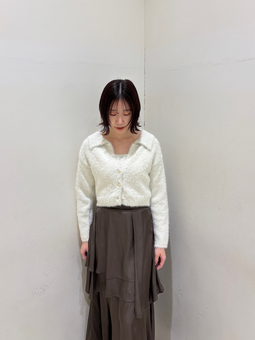 ブラウン系のスカート、ホワイト系のアンサンブルを着用したレディースの冬コーディネートの4枚目の写真