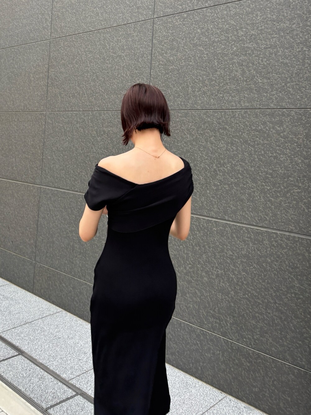 ブラウン系のパンプス、ブラウン系のボストンバッグ、ブラック系のワンピースを着用したレディースの夏コーディネートの6枚目の写真