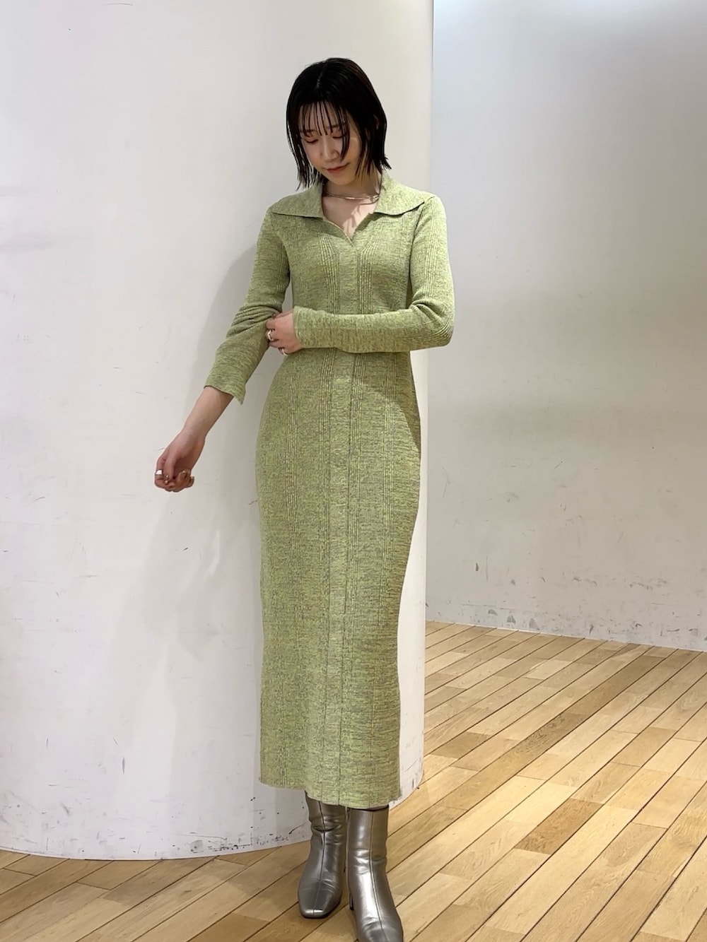 ホワイト系のカーディガン/ボレロ、グリーン系のワンピース、シルバー系のブーツを着用したレディースの冬コーディネートの6枚目の写真
