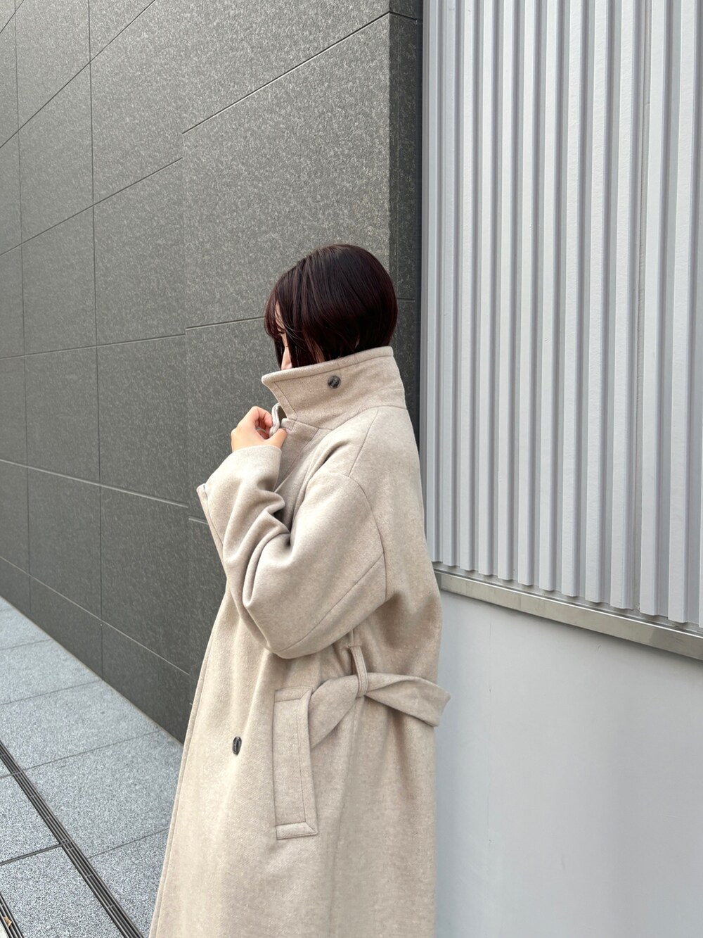 レッド系のワンピース、ホワイト系のチェスターコートを着用したレディースの冬コーディネートの7枚目の写真