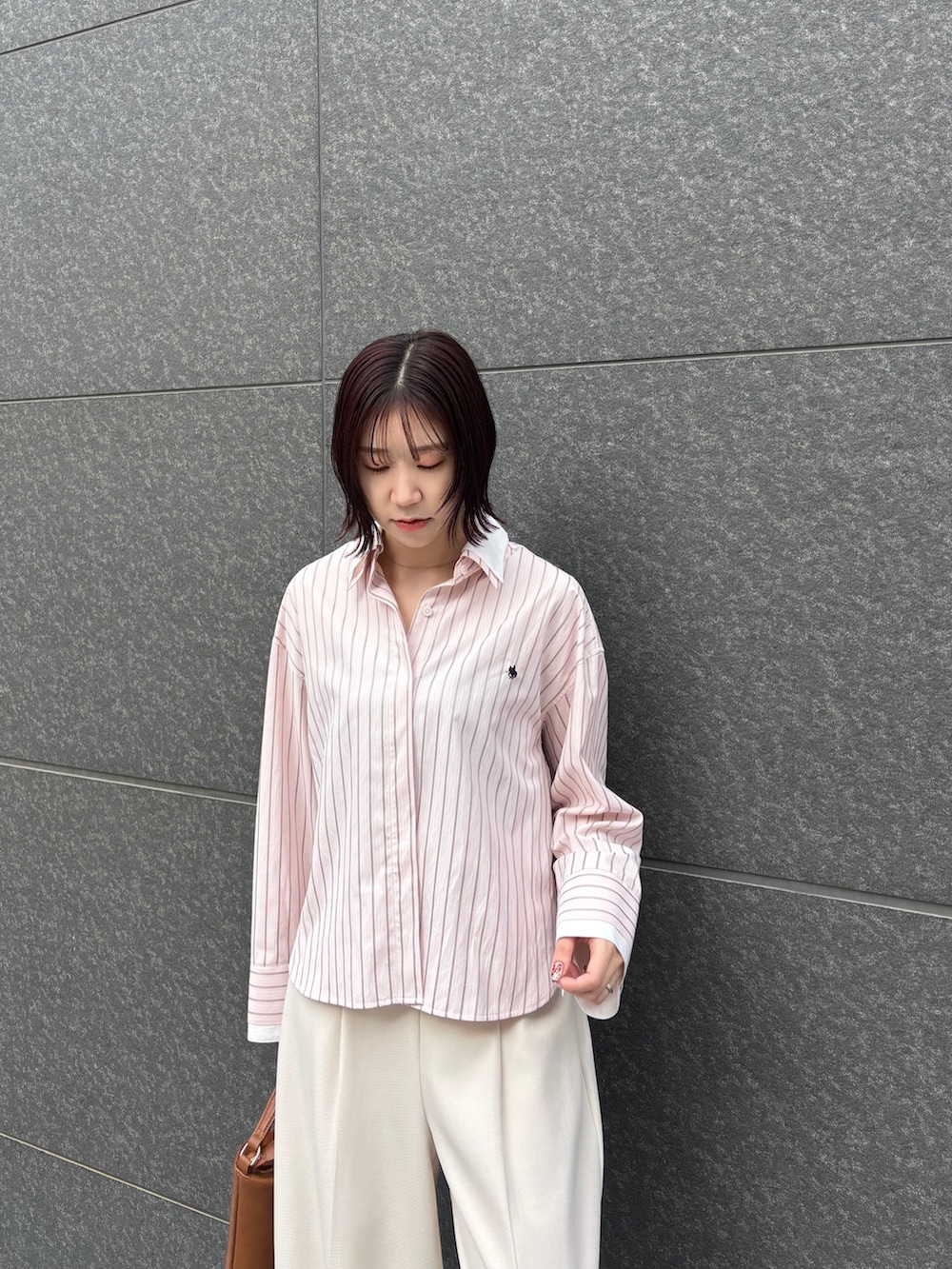 ピンク系のシャツ/ブラウス、ホワイト系のその他パンツ、イエロー系のハンドバッグを着用したレディースの春コーディネートの4枚目の写真