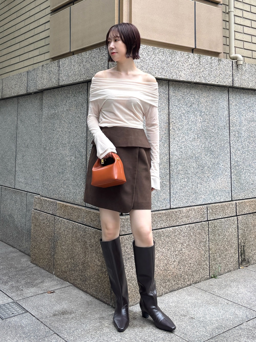 ブラウン系のブーツ、ブラウン系のハンドバッグ、ブラウン系のスカートを着用したレディースの秋コーディネートの8枚目の写真
