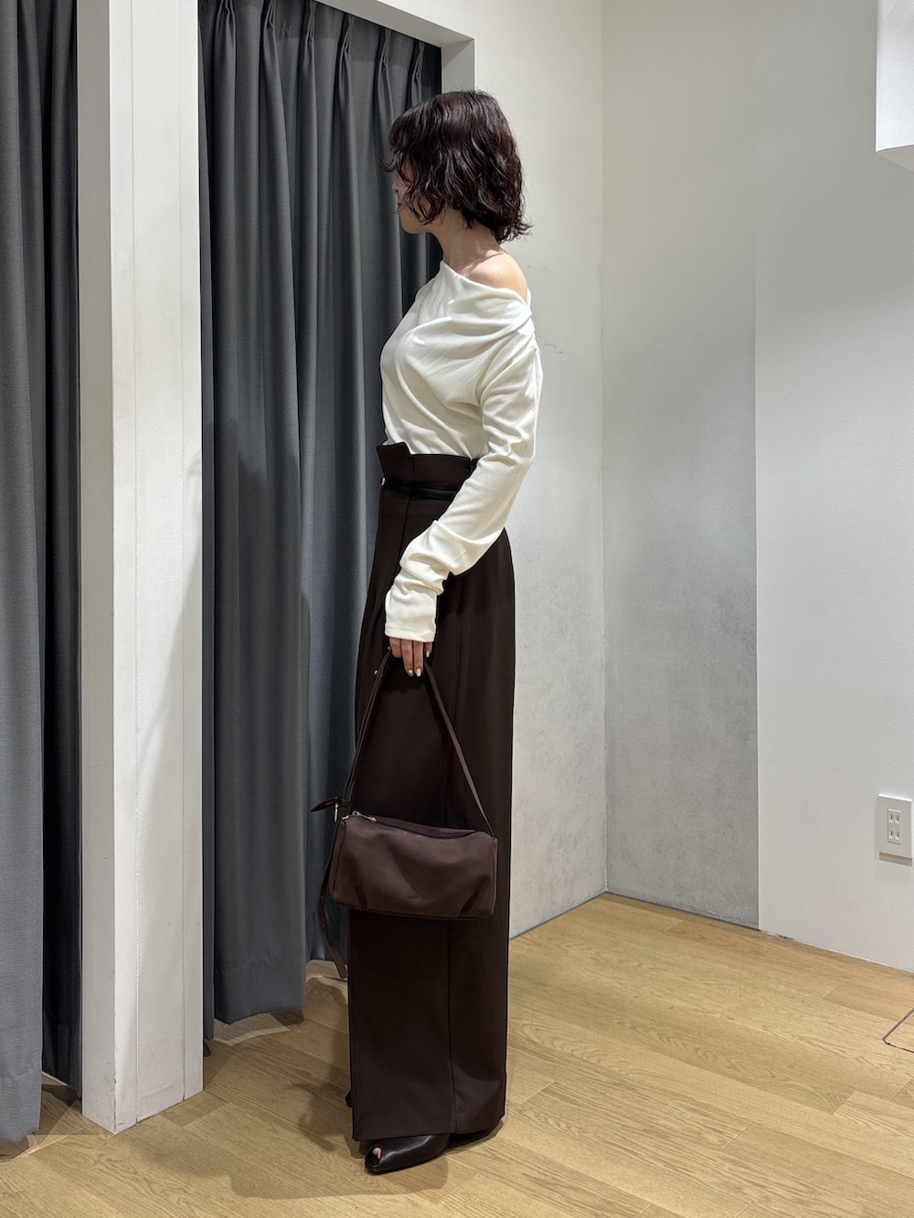 ブラウン系のその他パンツ、ホワイト系のニット/セーター、ブラウン系のハンドバッグを着用したレディースの秋コーディネートの2枚目の写真