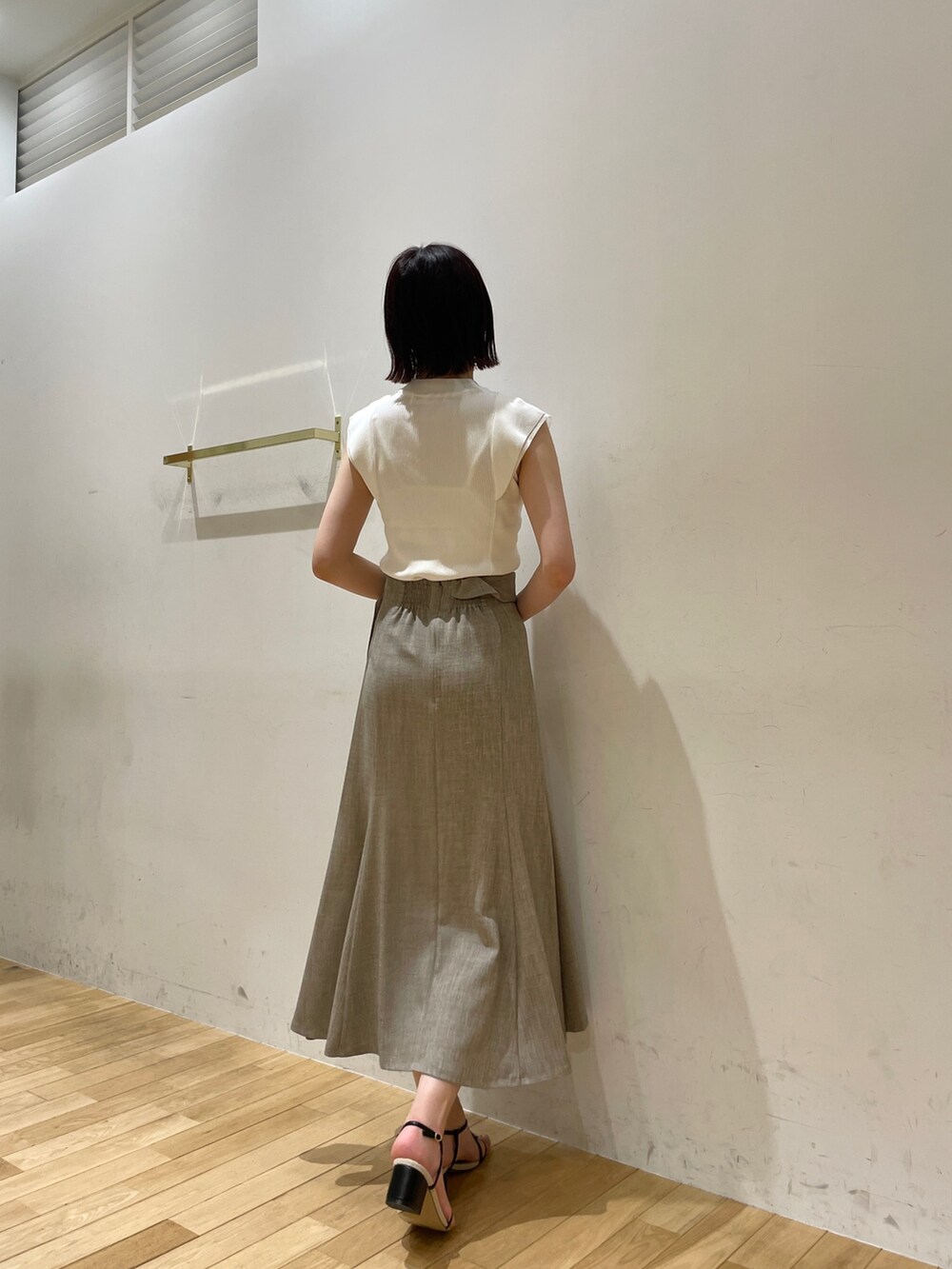 イエロー系のサンダル、ベージュ系のスカート、ホワイト系のニット/セーターを着用したレディースの夏コーディネートの5枚目の写真