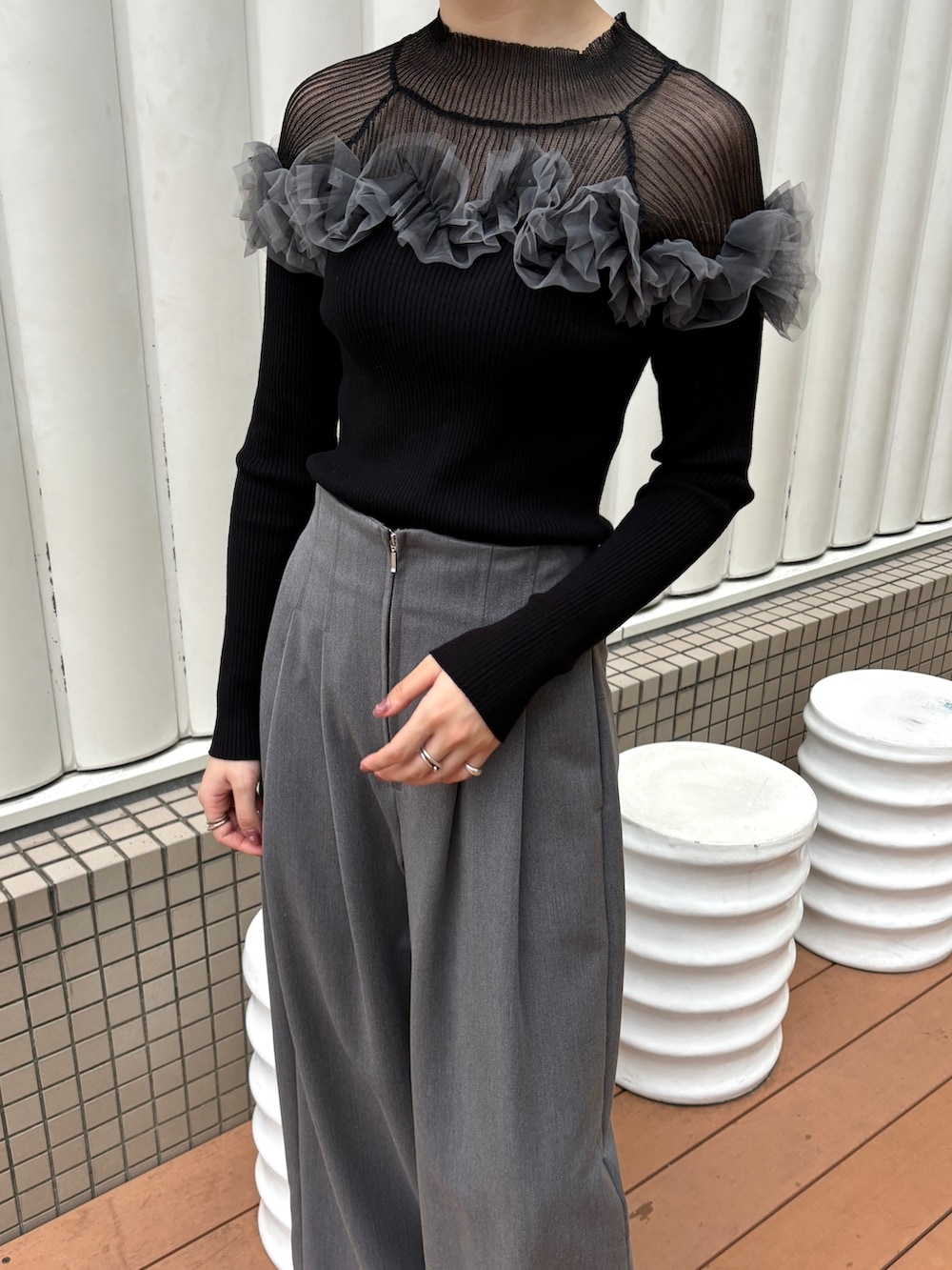 グレー系のその他パンツ、ブラック系のニット/セーター、ブラック系のブーツを着用したレディースの秋コーディネートの6枚目の写真