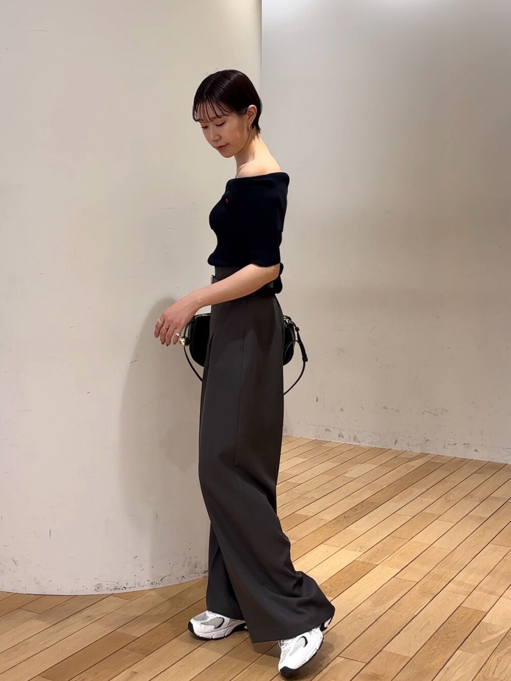 グレー系のその他パンツ、ブルー系のニット/セーター、ブラック系のショルダーバッグを着用したレディースの春コーディネートの3枚目の写真