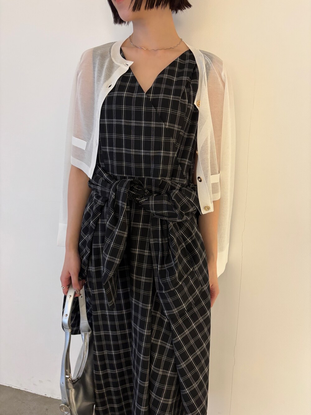 ホワイト系のカーディガン/ボレロ、シルバー系のパンプス、シルバー系のハンドバッグを着用したレディースの春コーディネートの2枚目の写真