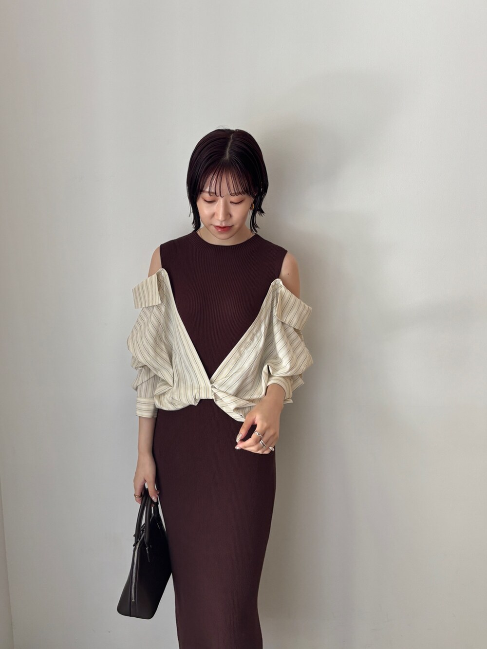 ブラウン系のワンピース、ブラウン系のボストンバッグ、ブラウン系のパンプスを着用したレディースの秋コーディネートの5枚目の写真