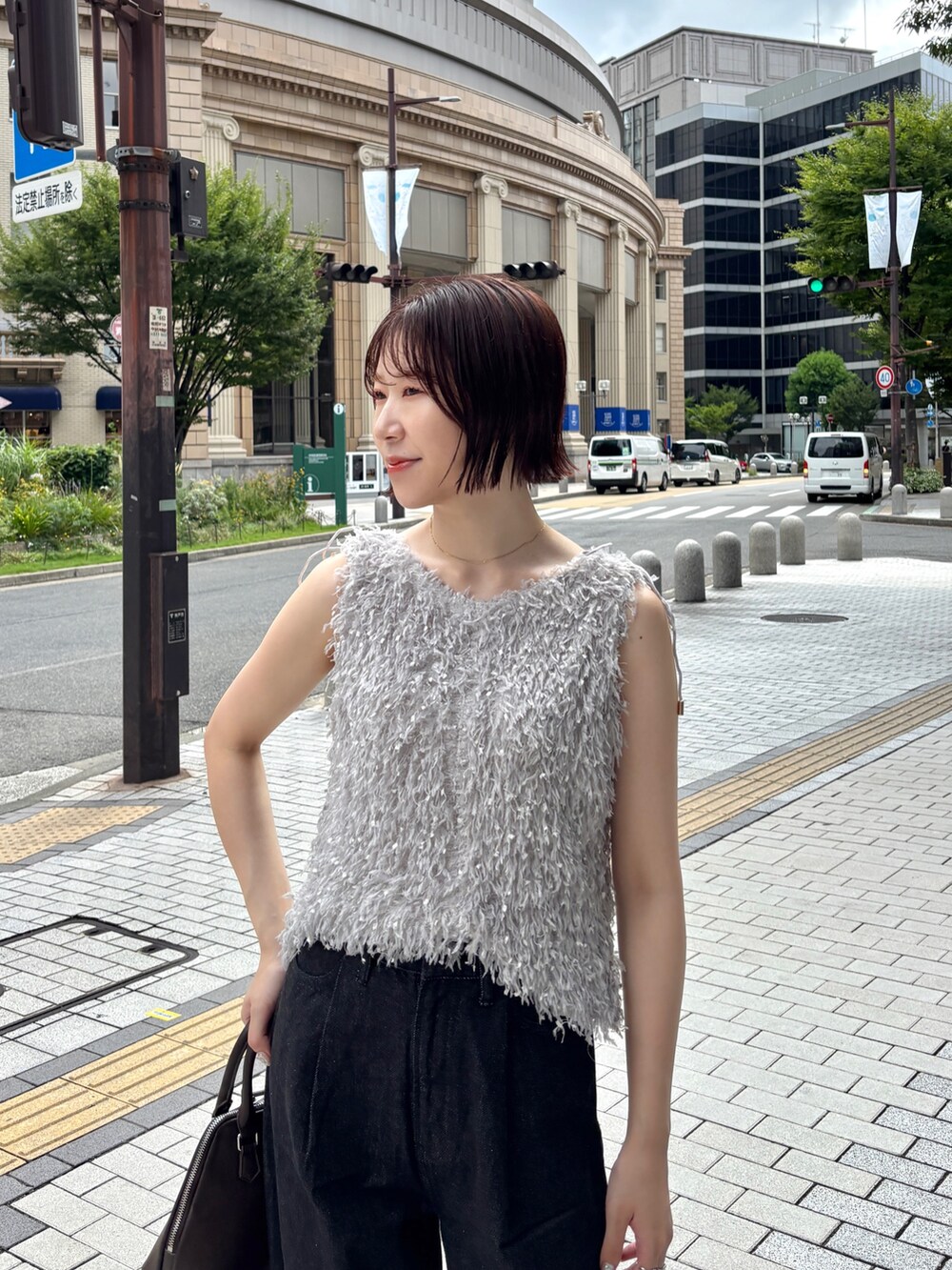 ブラウン系のパンプス、ブラック系のデニムパンツ、ブラウン系のボストンバッグを着用したレディースの夏コーディネートの7枚目の写真