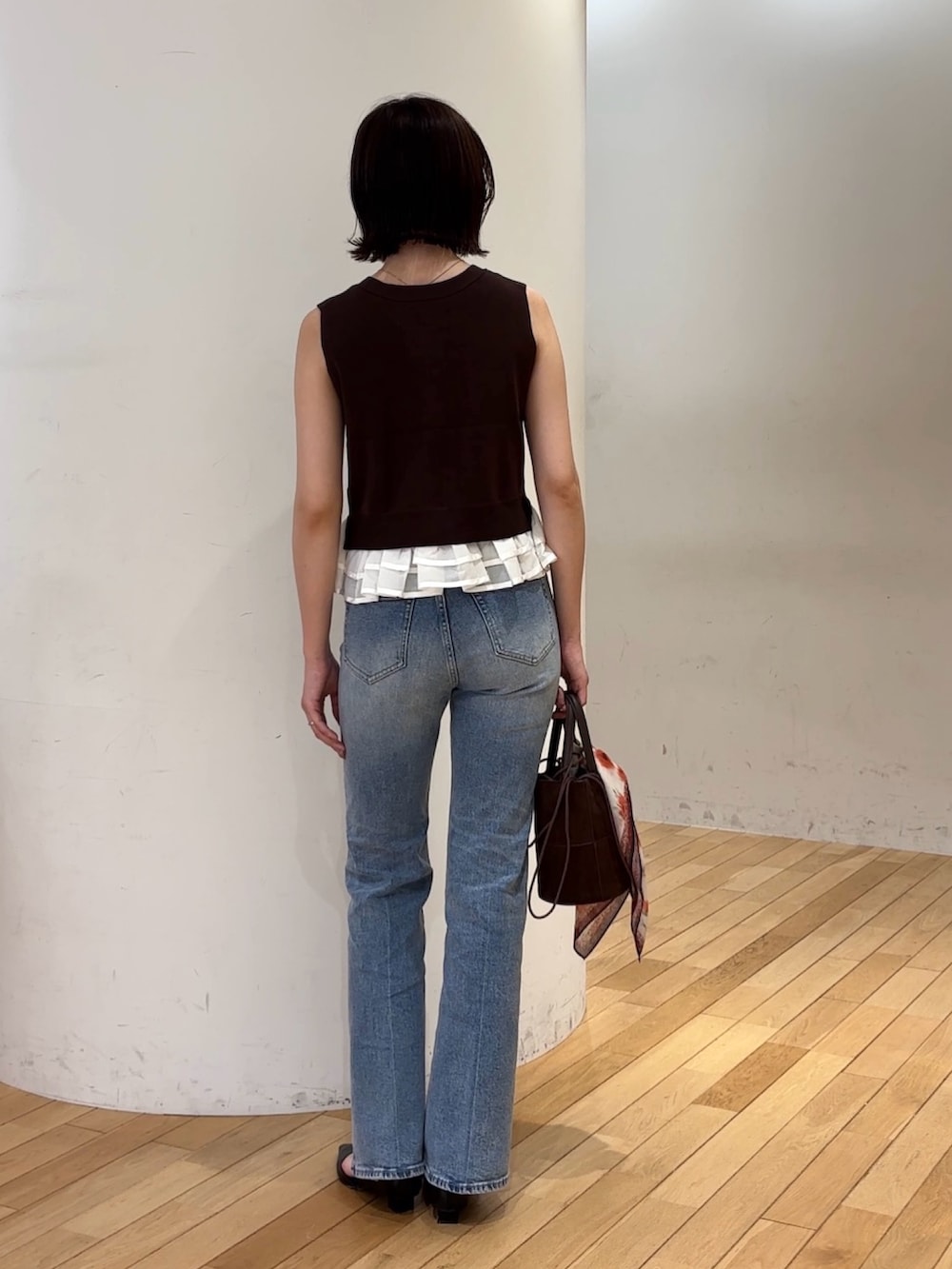ブラウン系のニット/セーター、ブルー系のデニムパンツ、ブラック系のパンプスを着用したレディースの夏コーディネートの3枚目の写真