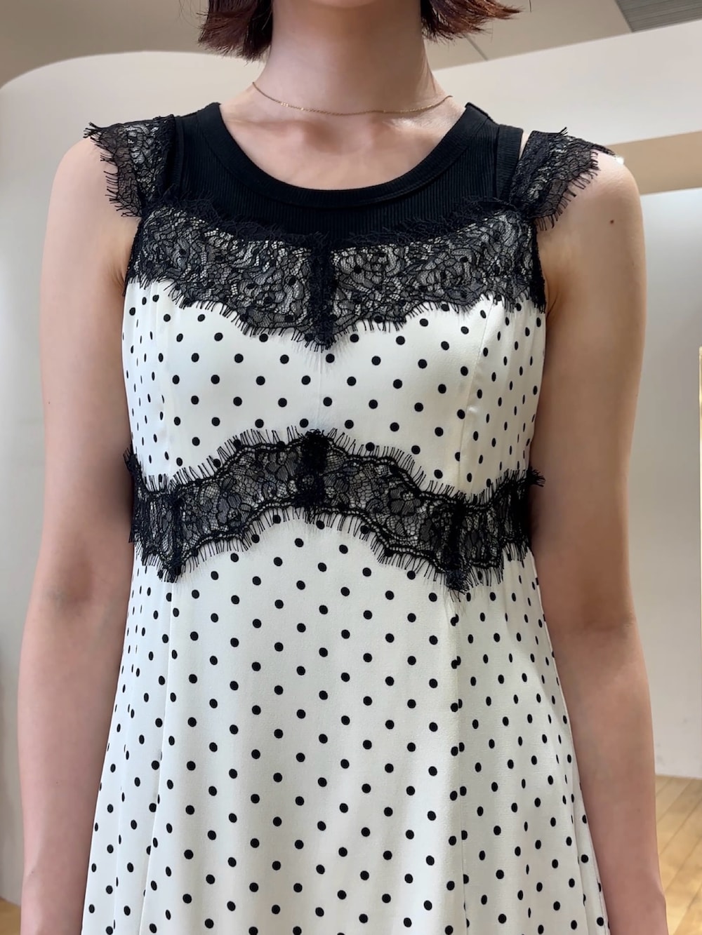 ホワイト系のワンピース、ブラック系のタンクトップ、ホワイト系のサンダルを着用したレディースの夏コーディネートの4枚目の写真