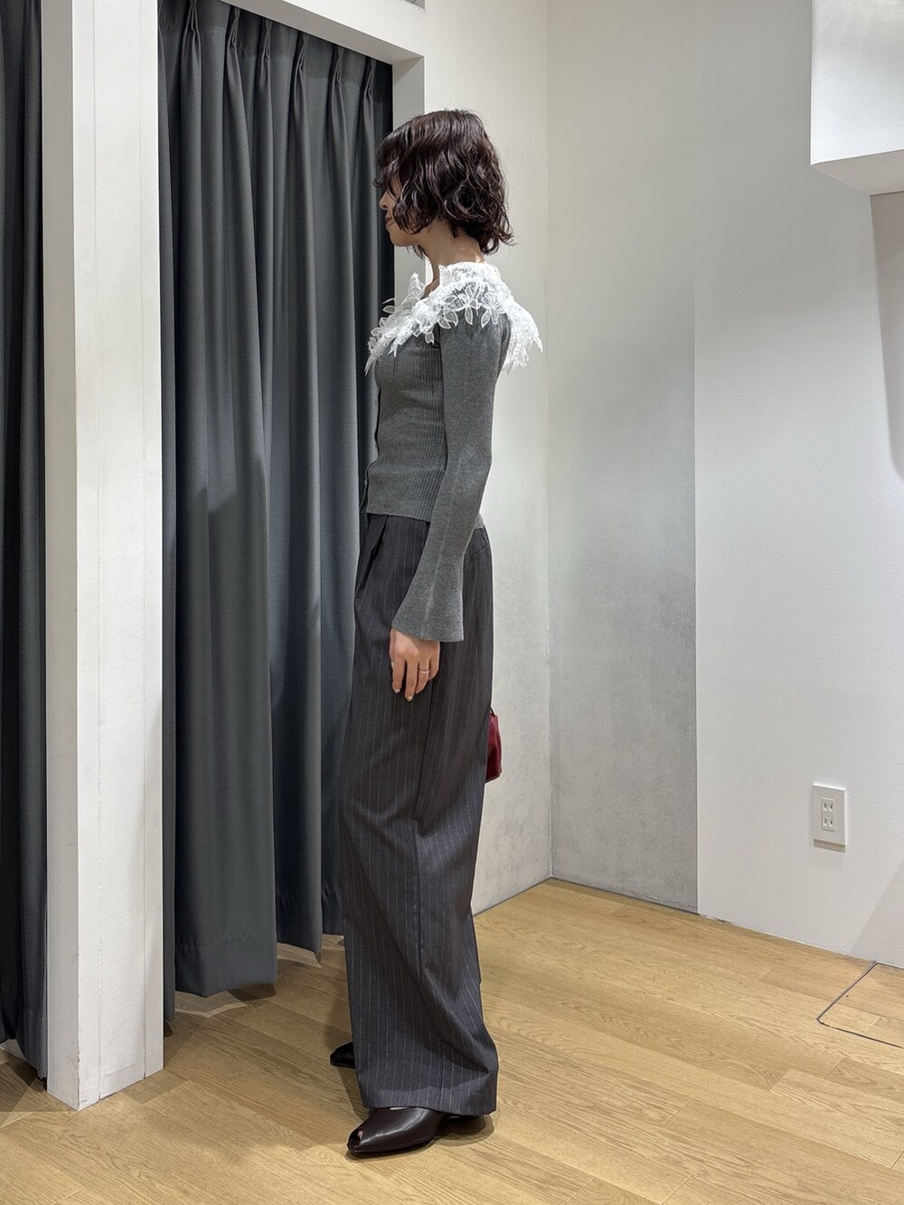 グレー系のその他パンツ、レッド系のハンドバッグ、ブラウン系のパンプスを着用したレディースの秋コーディネートの3枚目の写真