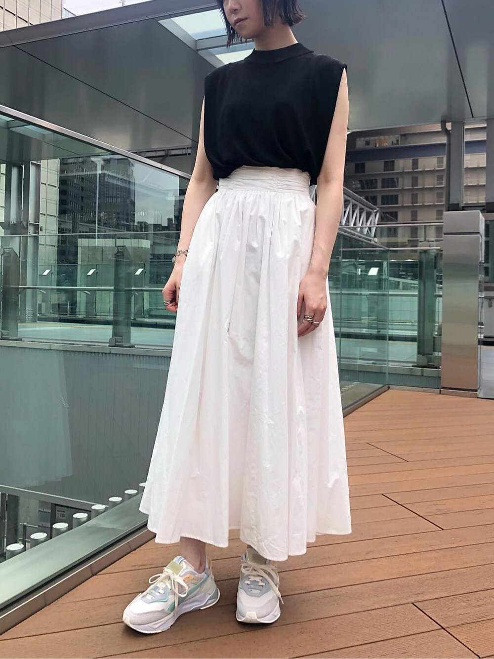 ブラック系のサンダル、ホワイト系のスカート、ブラック系のニット/セーターを着用したレディースの夏コーディネートの2枚目の写真