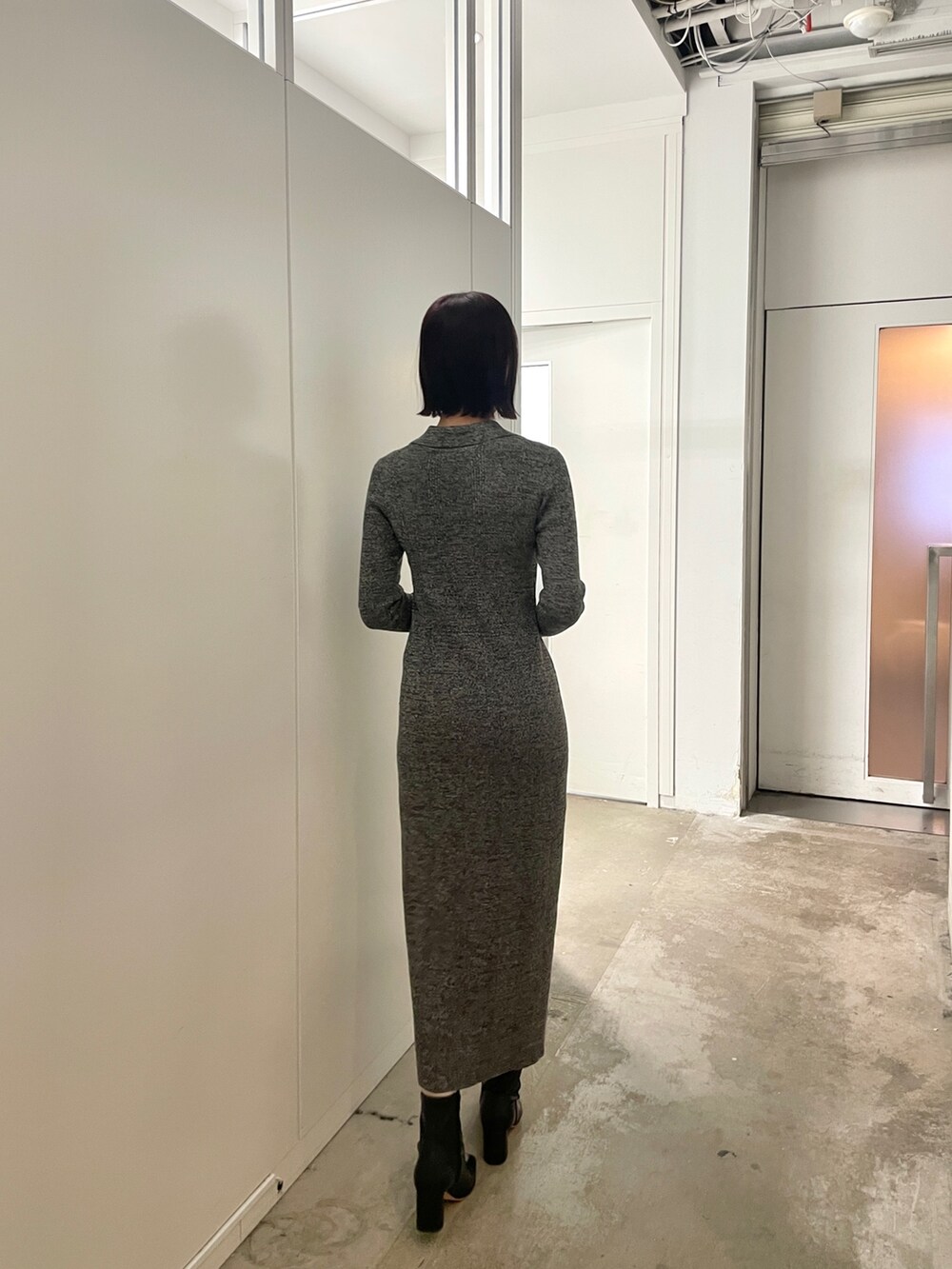 ブラック系のブーツ、グレー系のワンピースを着用したレディースの春コーディネートの6枚目の写真