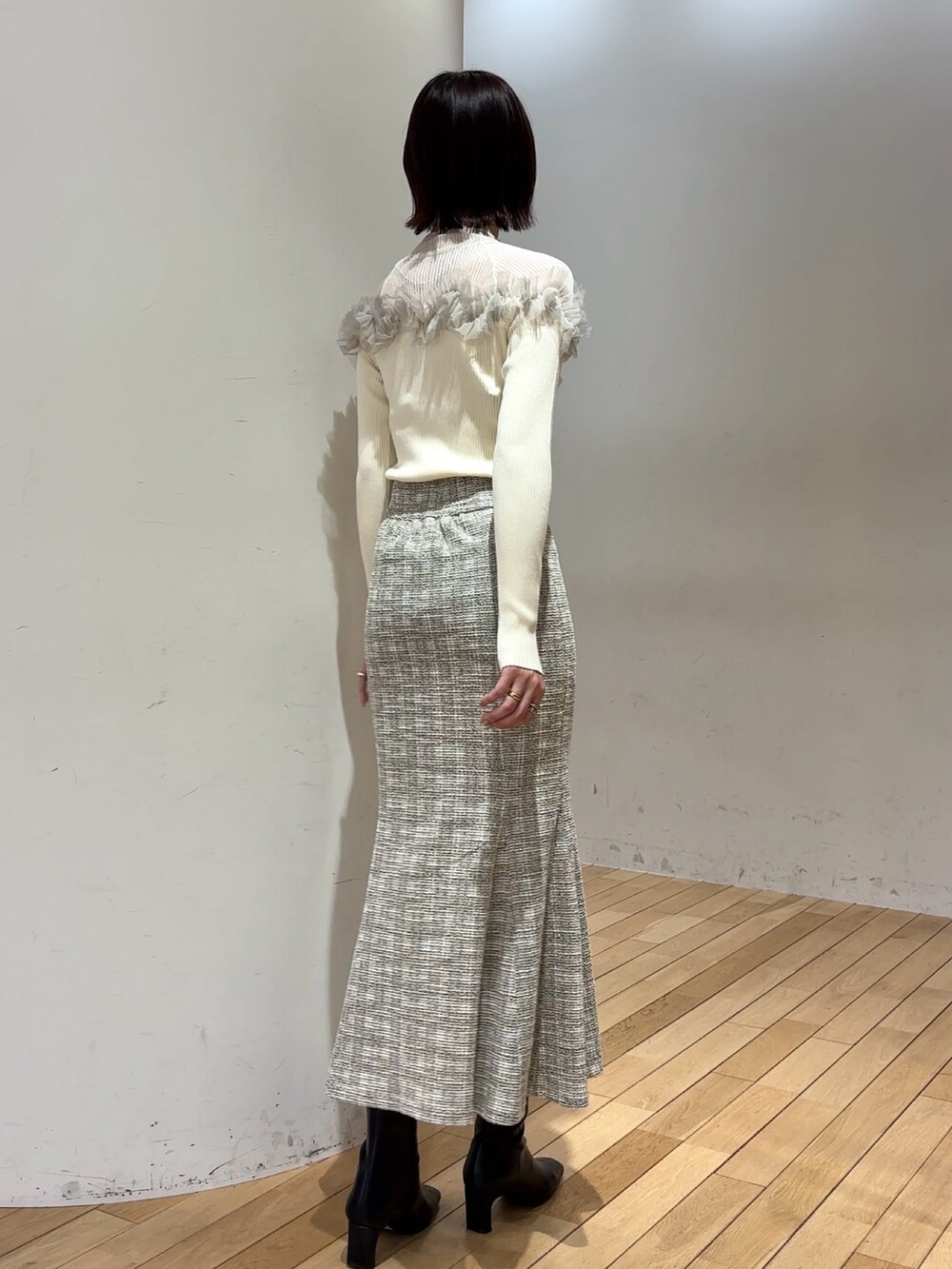 ブラック系のブーツ、ホワイト系のニット/セーター、ホワイト系のスカートを着用したレディースの冬コーディネートの4枚目の写真