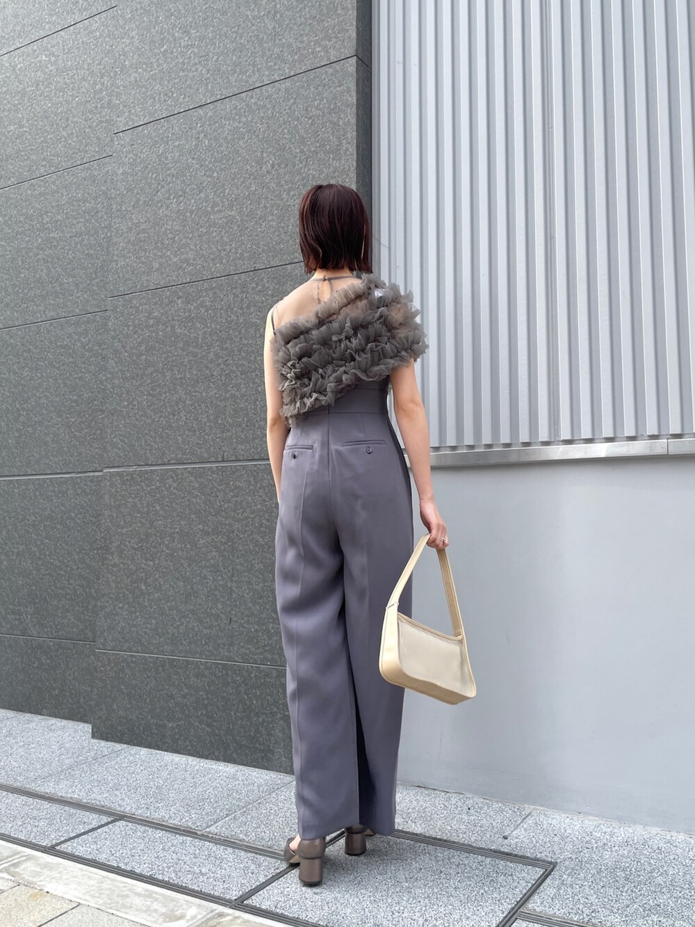 その他のパンプス、グレー系のパンツドレス、ベージュ系のハンドバッグを着用したレディースの春コーディネートの6枚目の写真