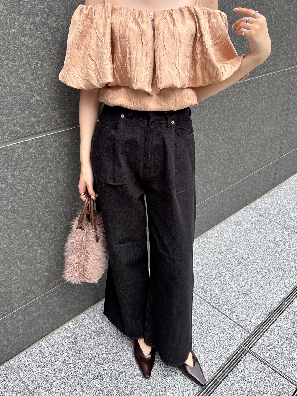 ブラック系のデニムパンツ、ブラウン系のパンプス、ブラウン系のボストンバッグを着用したレディースの夏コーディネートの3枚目の写真