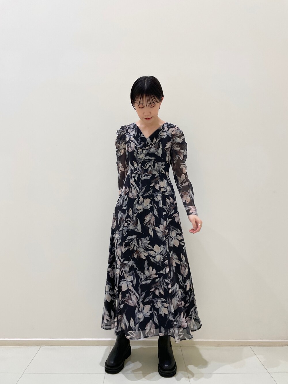 ホワイト系のカーディガン/ボレロ、ブルー系のワンピース、ブラック系のブーツを着用したレディースの冬コーディネートの8枚目の写真