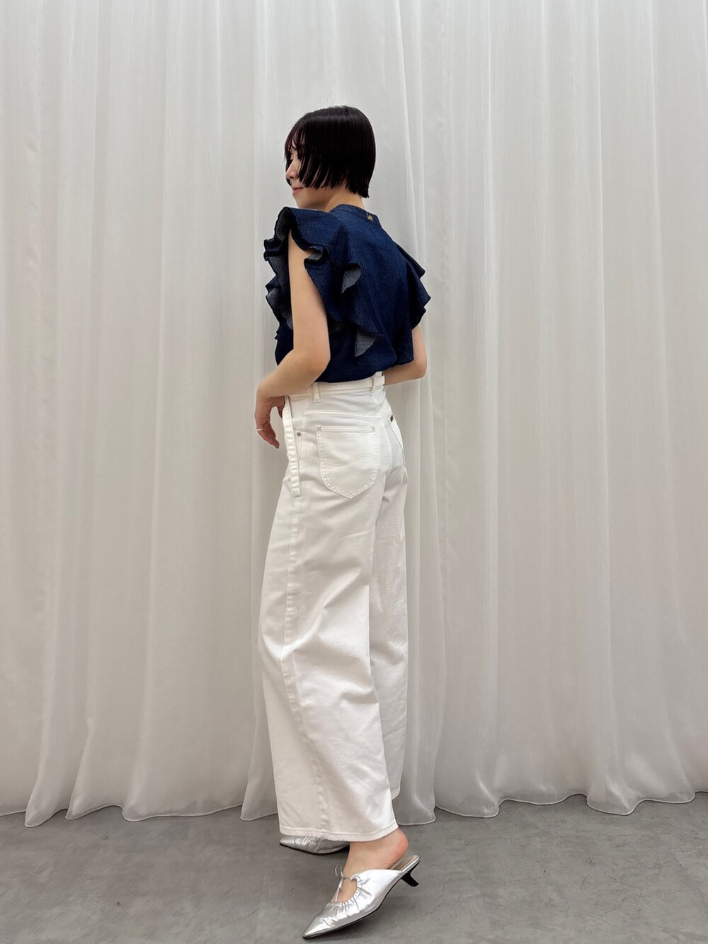 ホワイト系のデニムパンツ、ブルー系のシャツ/ブラウス、シルバー系のサンダルを着用したレディースの春コーディネートの3枚目の写真