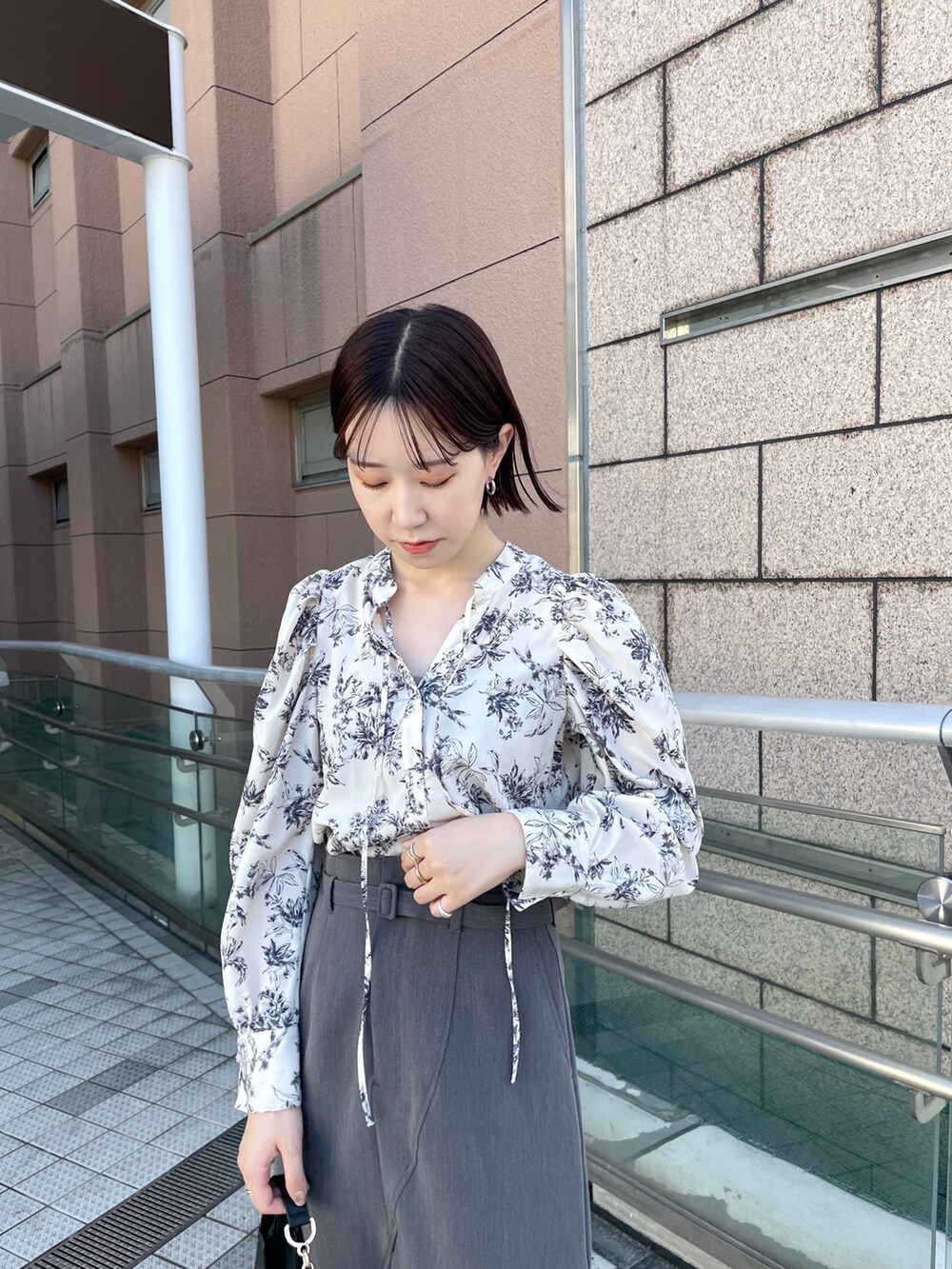 グレー系のスカート、ホワイト系のシャツ/ブラウス、ホワイト系のブーツを着用したレディースの秋コーディネートの4枚目の写真