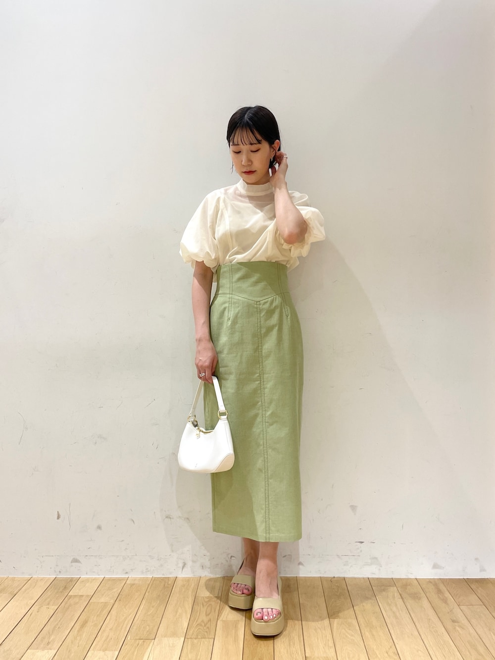 ベージュ系のサンダル、グリーン系のスカート、ホワイト系のシャツ/ブラウスを着用したレディースの夏コーディネートの3枚目の写真
