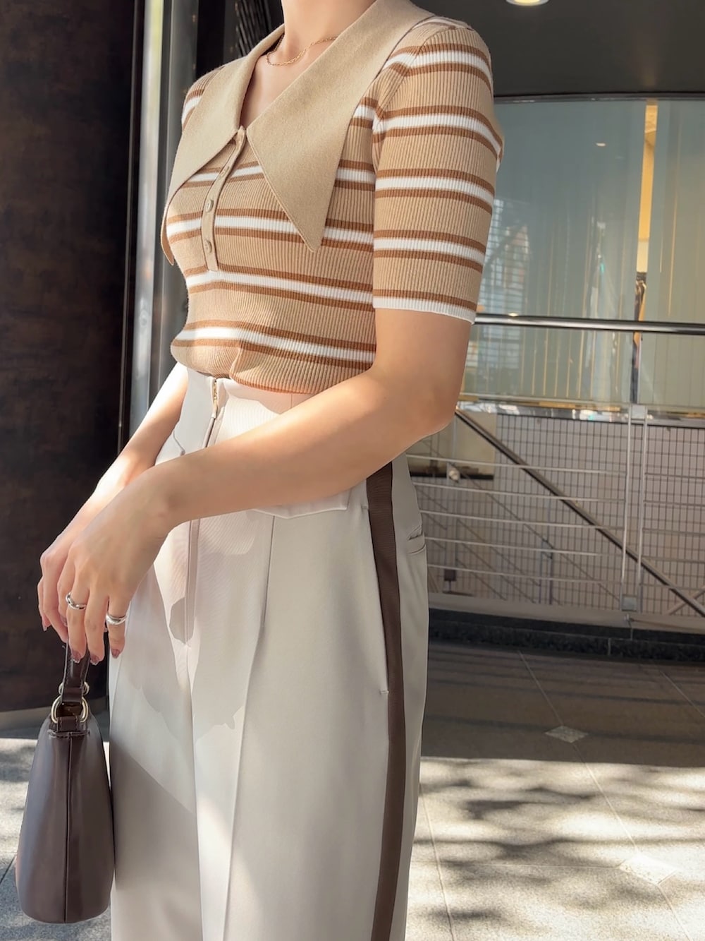 ホワイト系のその他パンツ、シルバー系のパンプス、ブラウン系のハンドバッグを着用したレディースの冬コーディネートの6枚目の写真