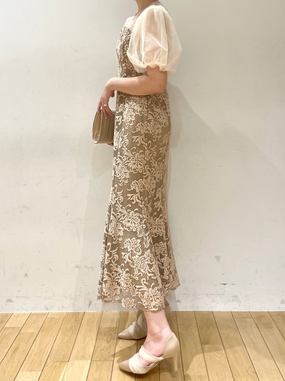 ベージュ系のハンドバッグ、ベージュ系のパンプス、ベージュ系のドレスを着用したレディースの秋コーディネートの4枚目の写真