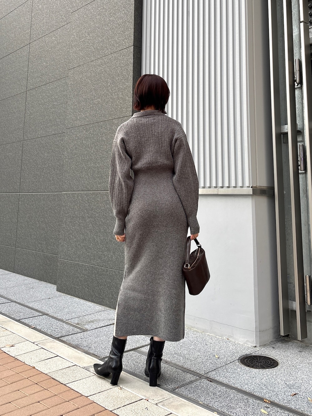 グレー系のワンピース、ブラウン系のハンドバッグ、ブラック系のブーツを着用したレディースの冬コーディネートの3枚目の写真