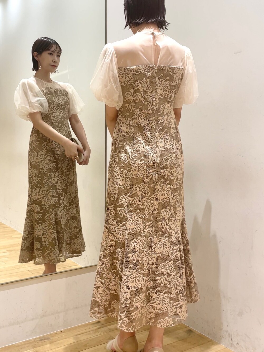 ベージュ系のハンドバッグ、ベージュ系のパンプス、ベージュ系のドレスを着用したレディースの秋コーディネートの7枚目の写真