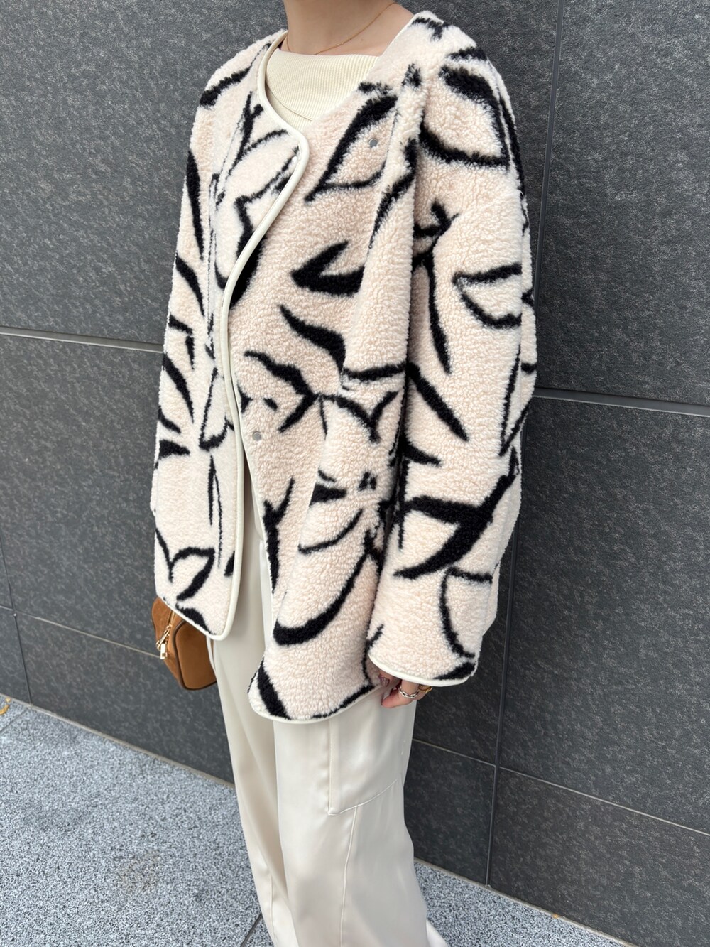 ホワイト系のブルゾン、ホワイト系のニット/セーター、ホワイト系のカーゴパンツを着用したレディースの冬コーディネートの7枚目の写真