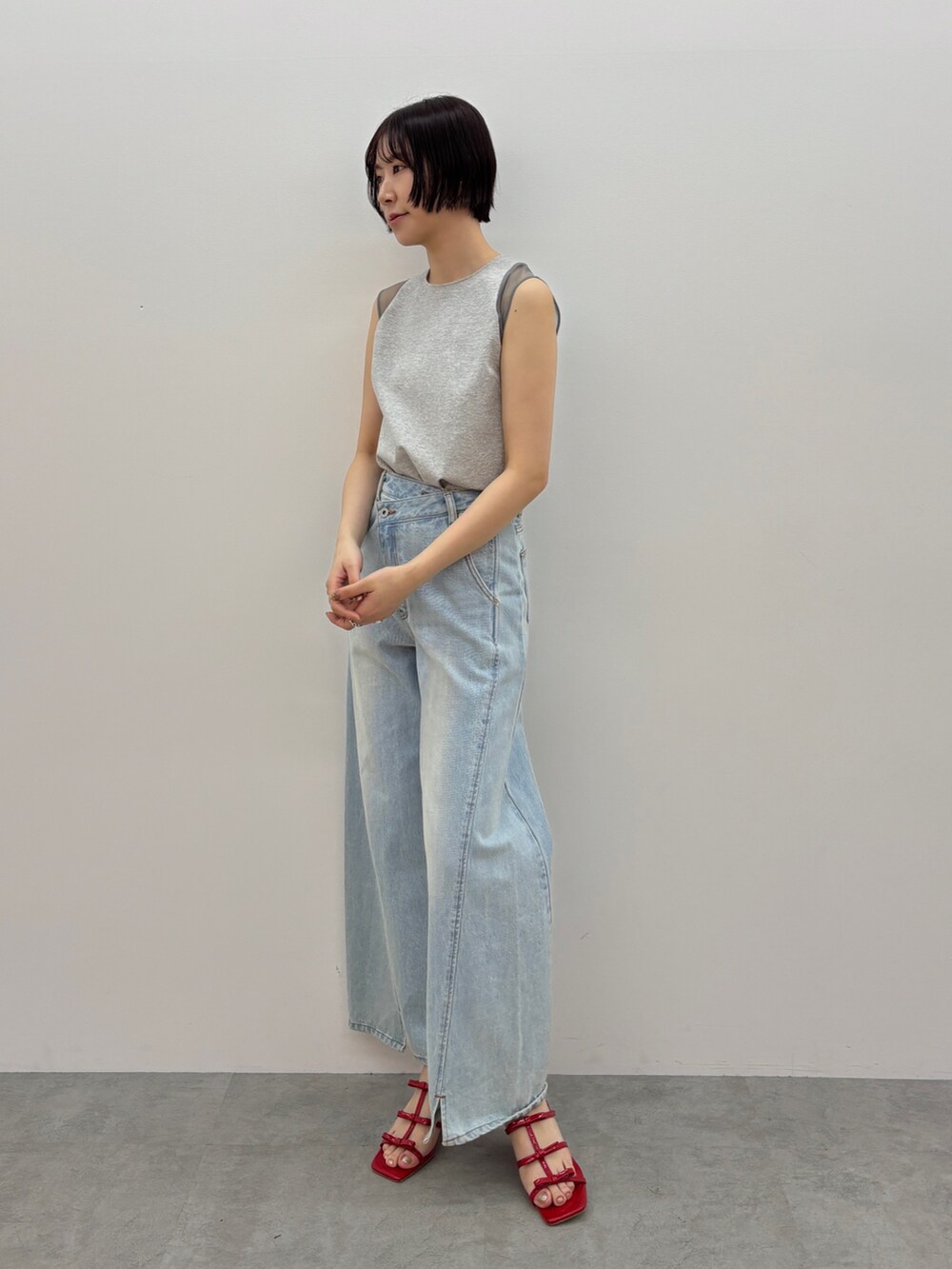ブルー系のデニムパンツ、レッド系のサンダル、グレー系のTシャツ/カットソーを着用したレディースの春コーディネートの2枚目の写真