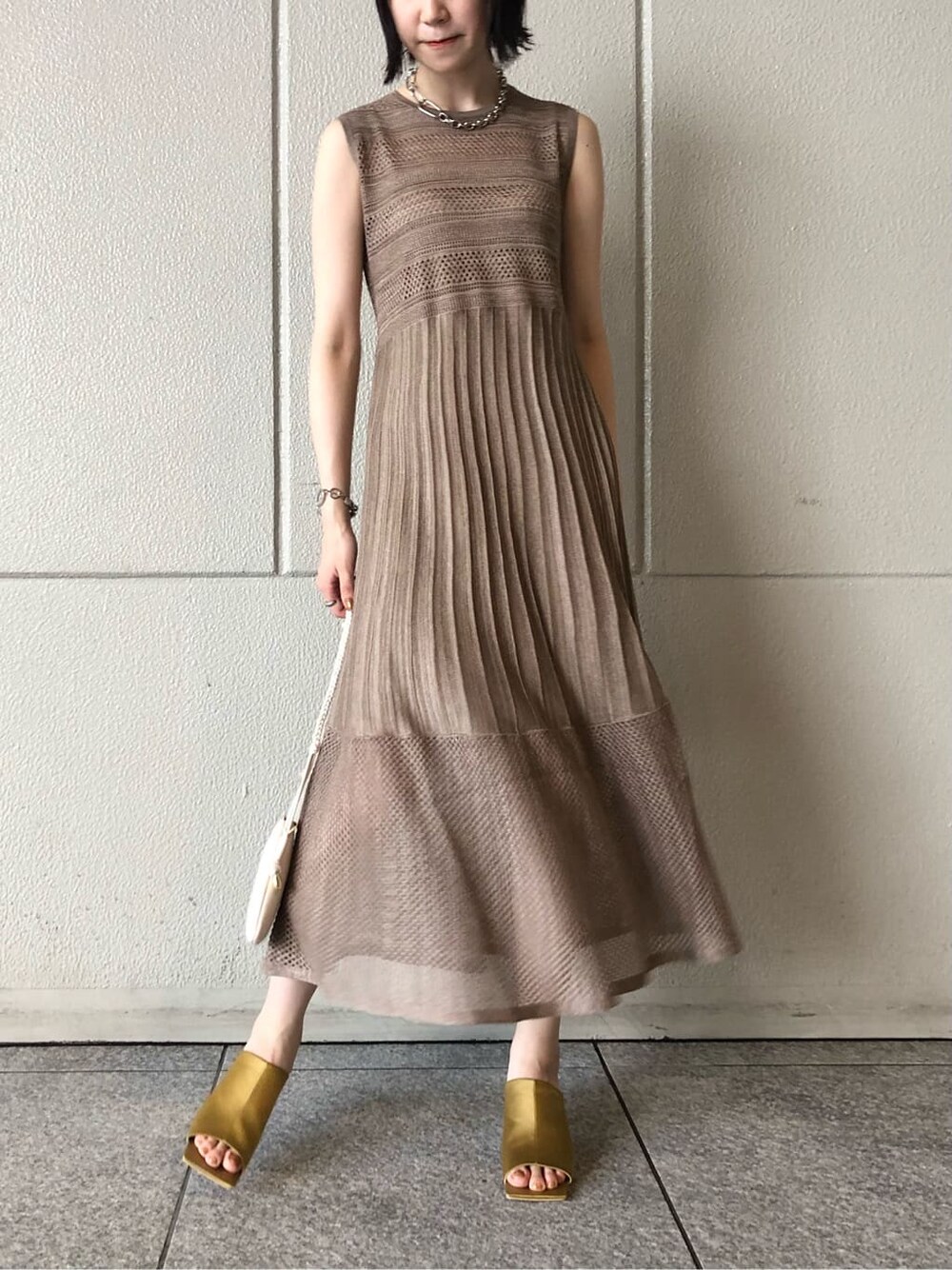 ホワイト系のショルダーバッグ、イエロー系のサンダル、ベージュ系のワンピースを着用したレディースの夏コーディネートの6枚目の写真