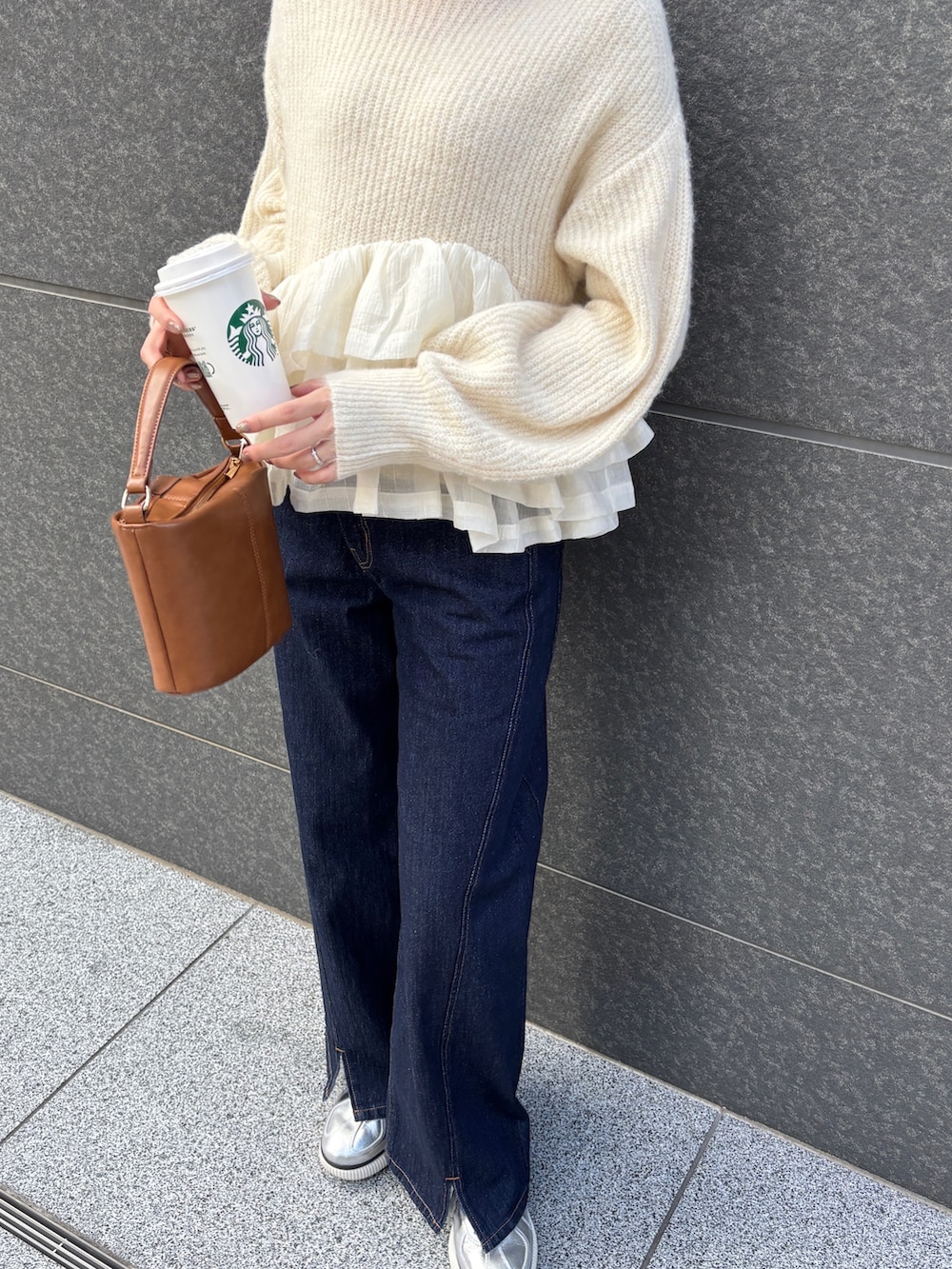 ブルー系のデニムパンツ、イエロー系のハンドバッグ、ホワイト系のニット/セーターを着用したレディースの冬コーディネートの6枚目の写真