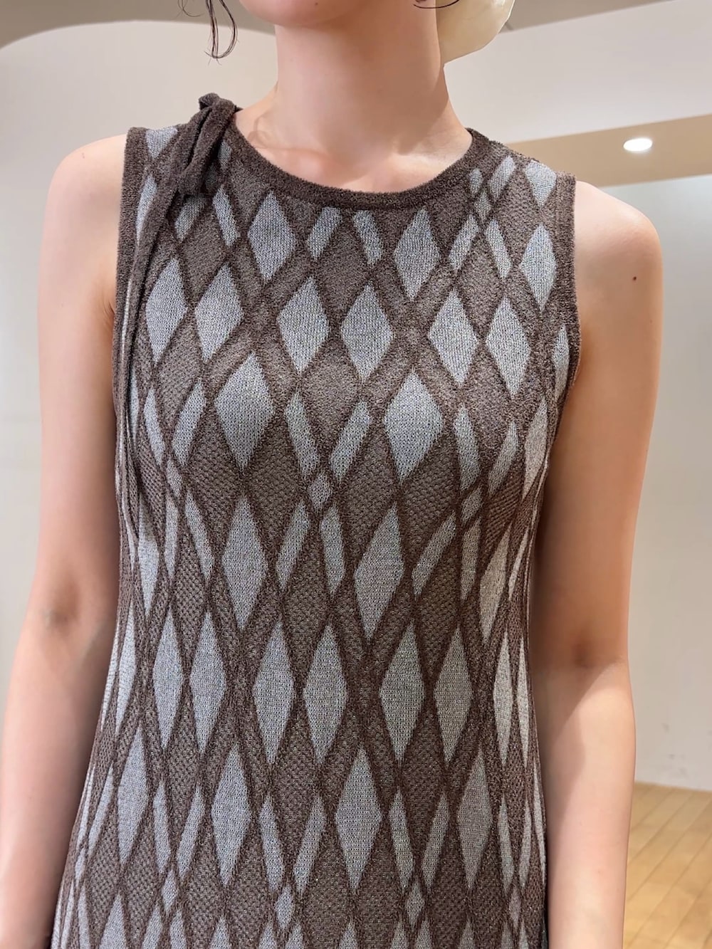 ブラウン系のワンピース、ブラウン系のハンドバッグ、ブラック系のサンダルを着用したレディースの夏コーディネートの4枚目の写真