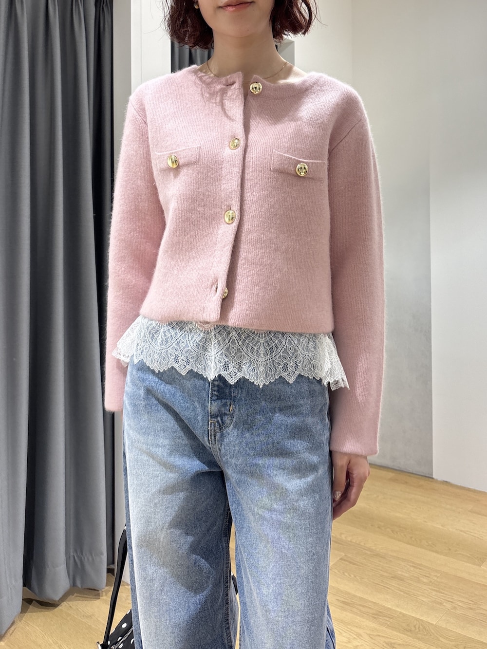 ブルー系のデニムパンツ、ピンク系のキャミソール、ピンク系のノーカラージャケットを着用したレディースの秋コーディネートの5枚目の写真