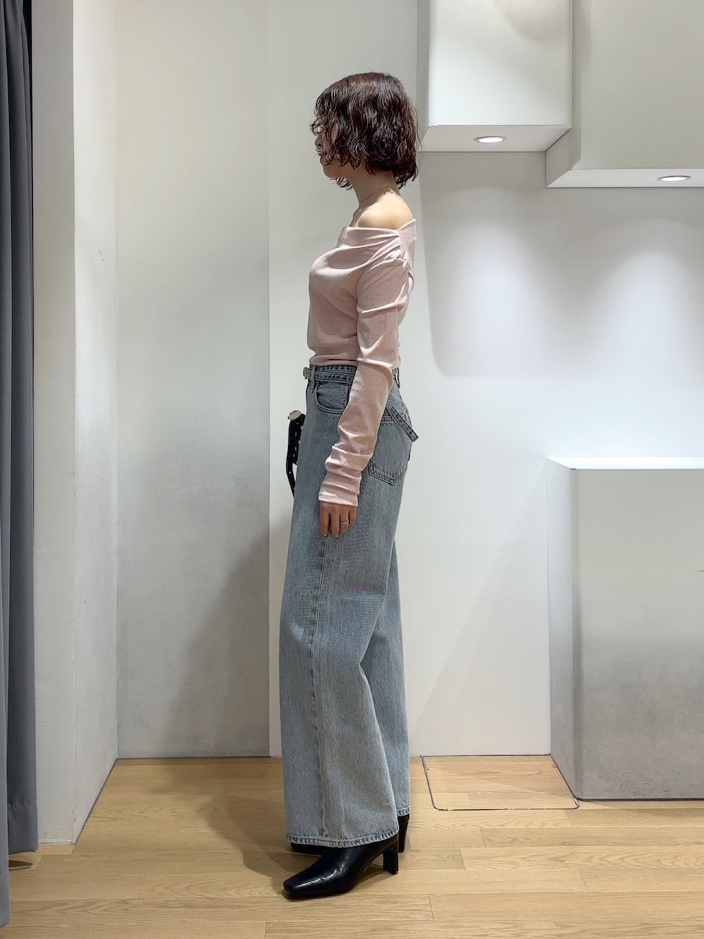 ピンク系のニット/セーター、ブルー系のデニムパンツ、ブラック系のブーツを着用したレディースの秋コーディネートの2枚目の写真