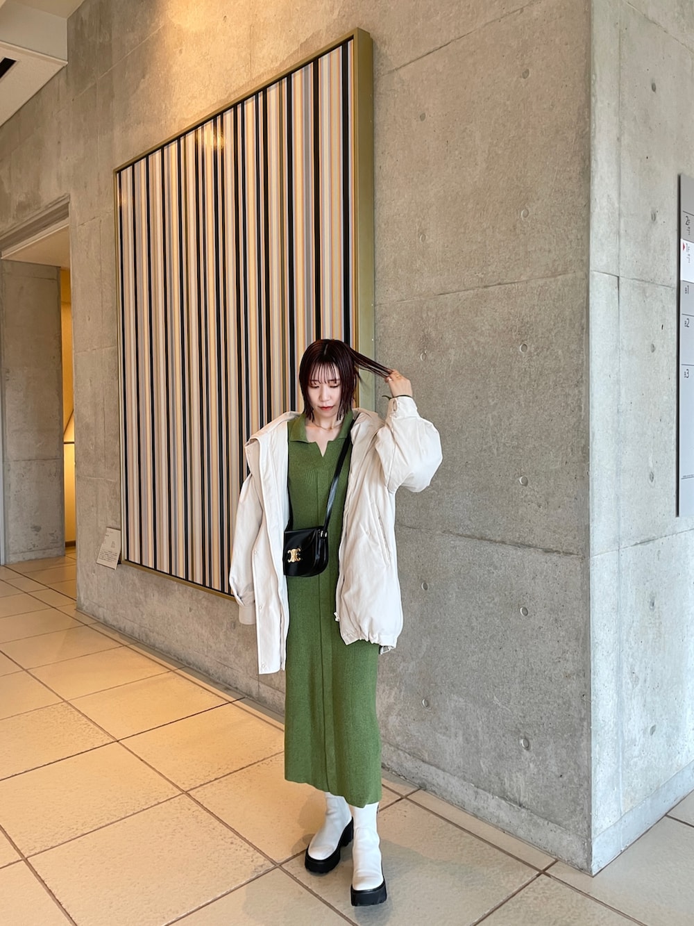 グリーン系のワンピース、ホワイト系のダウンジャケット/コートを着用したレディースの冬コーディネートの4枚目の写真