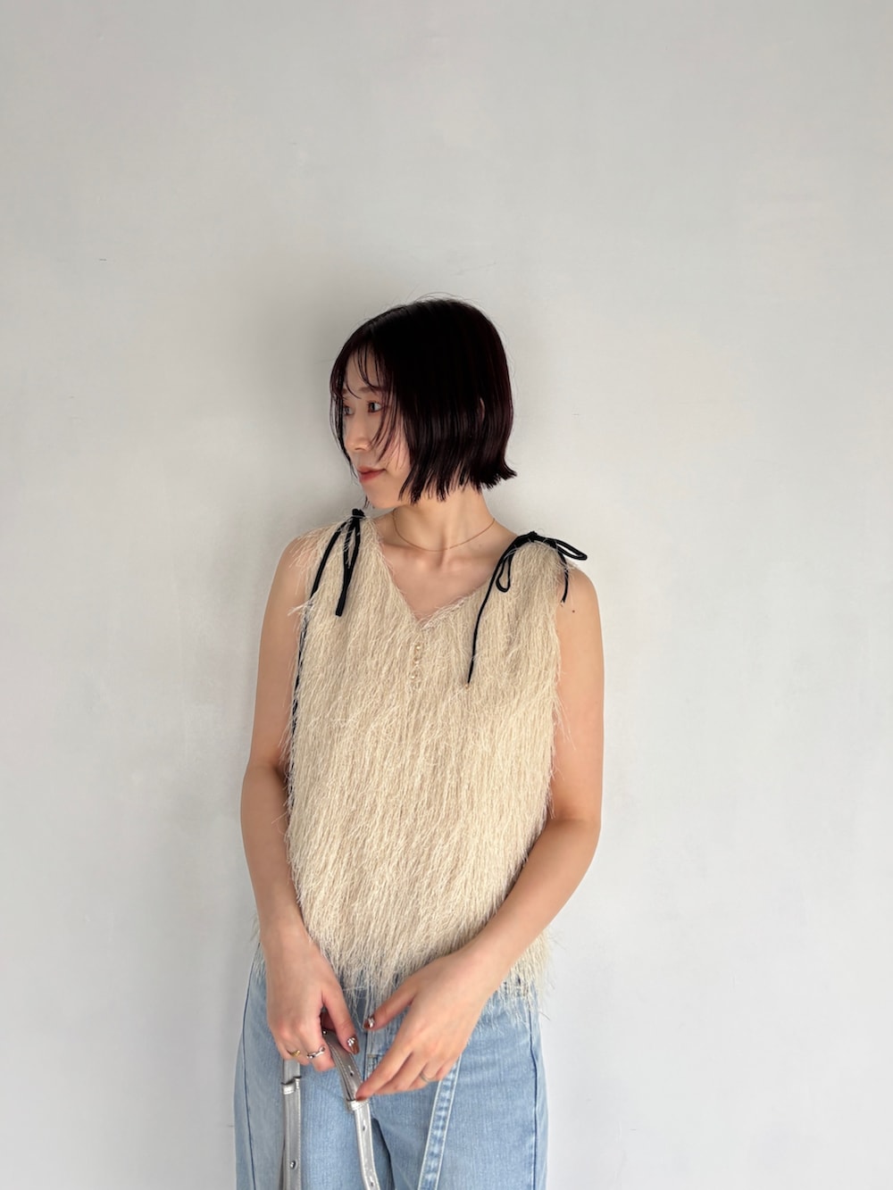 ホワイト系のTシャツ/カットソー、ブルー系のデニムパンツ、シルバー系のハンドバッグを着用したレディースの春コーディネートの5枚目の写真