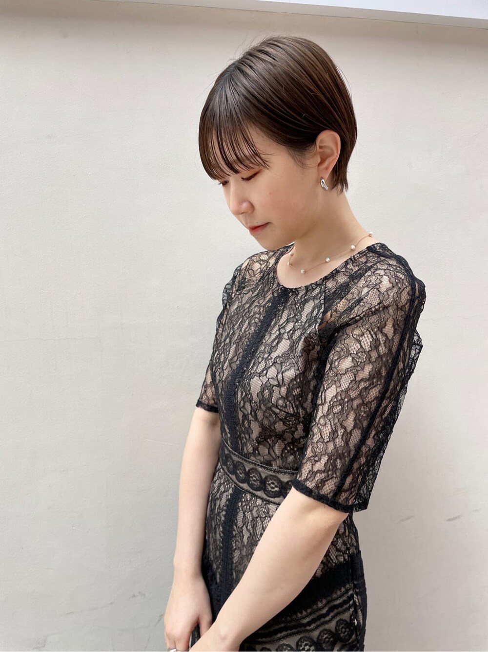 シルバー系のクラッチバッグ、ベージュ系のトレンチコート、シルバー系のパンプスを着用したレディースの冬コーディネートの5枚目の写真