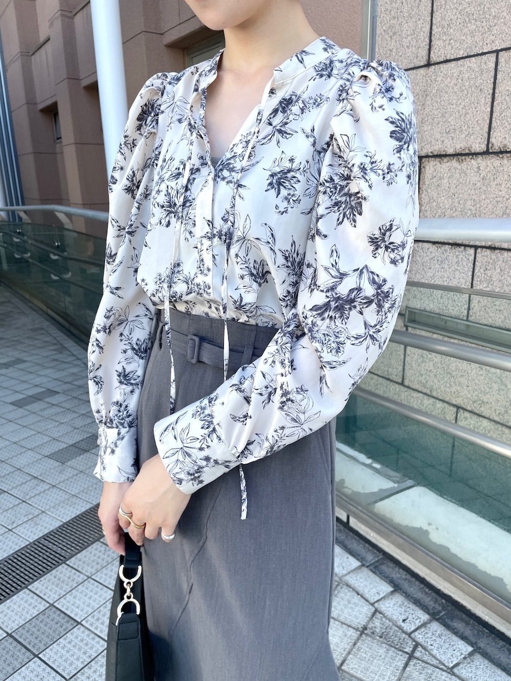 グレー系のスカート、ホワイト系のシャツ/ブラウス、ホワイト系のブーツを着用したレディースの秋コーディネートの5枚目の写真