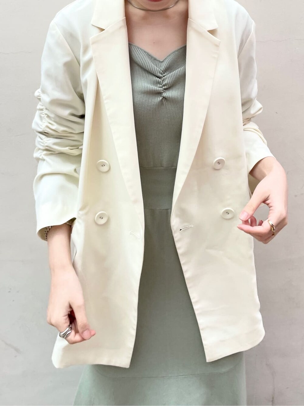 ブラック系のその他シューズ、ホワイト系のテーラードジャケット、グリーン系のワンピースを着用したレディースの冬コーディネートの4枚目の写真