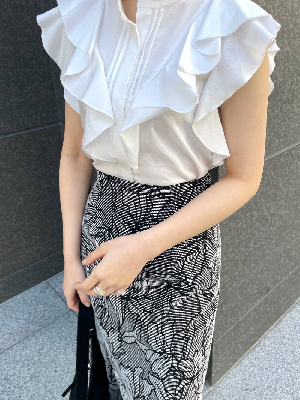 ホワイト系のシャツ/ブラウス、ブラック系のスカート、ブラック系のハンドバッグを着用したレディースの春コーディネートの6枚目の写真