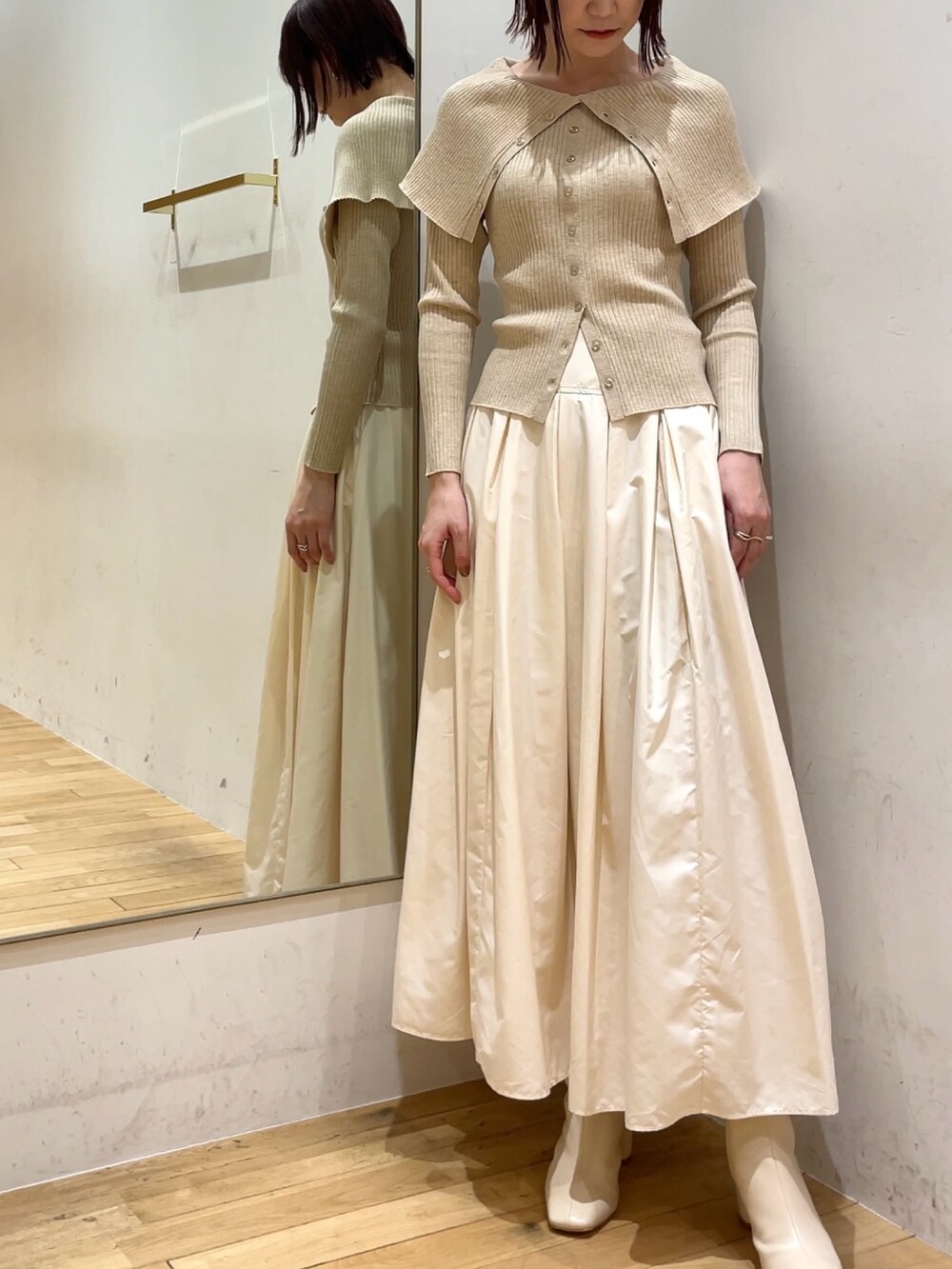 ホワイト系のブーツ、ホワイト系のスカート、ベージュ系のニット/セーターを着用したレディースの冬コーディネートの3枚目の写真