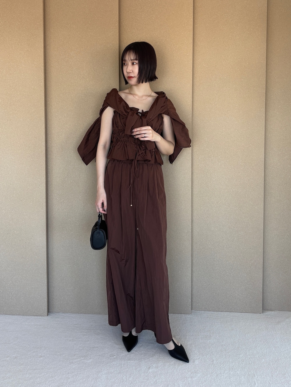 ブラウン系のその他パンツ、ブラック系のパンプス、ブラウン系のキャミソールを着用したレディースの春コーディネートの5枚目の写真
